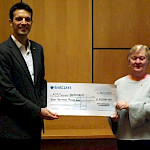Man and woman holding large cheque